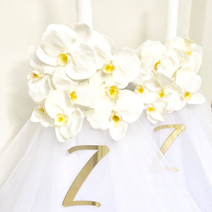 Our collection of exquisite Orthodox White Florals with Orchid candles, are meticulously crafted to add a touch of beauty and spirituality to your religious ceremonies.